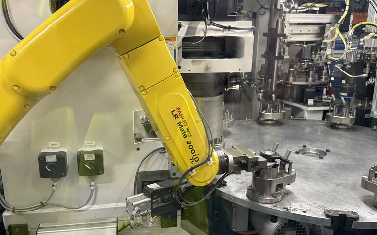 A yellow robot does things with other machnes and parts.