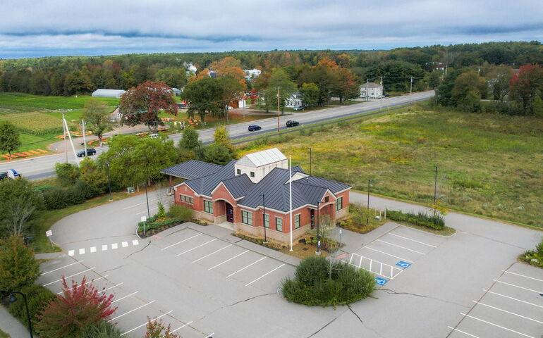 An aerial view of a brick building with a parking lot.