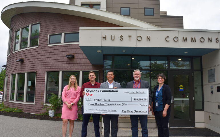 Four people hold up a Key Bank Foundation check.