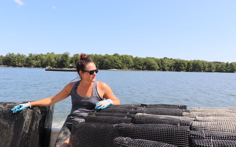 Kat Lipp is surrounded by netting near the water.