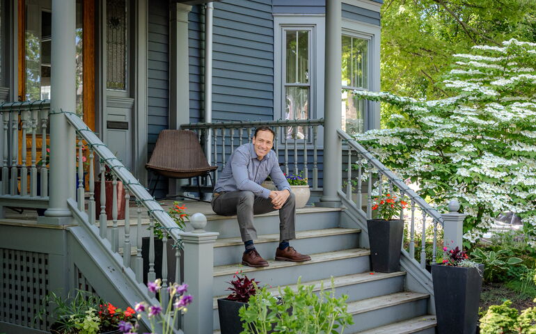 Tom Landry sits on some porch stairs.