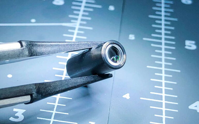 An instrument holds a small lens.