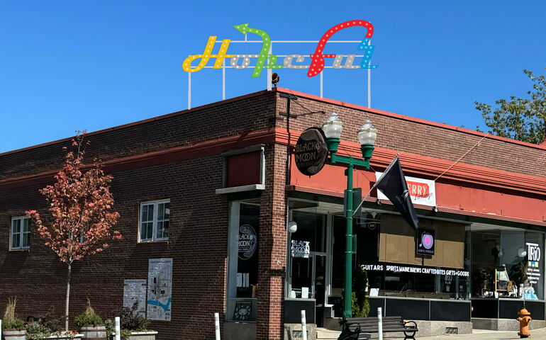 A composite image shows a sign on top of a building