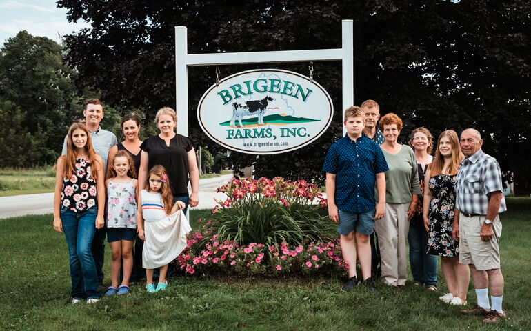 The Briggs family stands next to their farm sign.