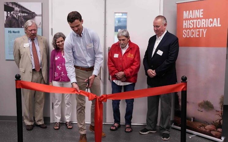 People  pose at a ribbon-cutting.