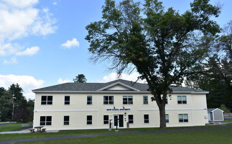 An apartment building with light yellow siding.