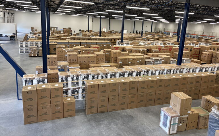 A warehouse interior with lots of stacks boxes.
