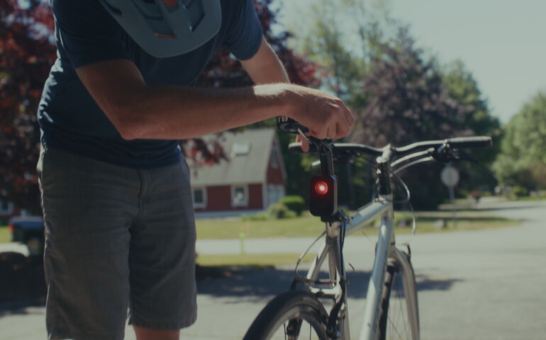 A person affixes a device to a bike.