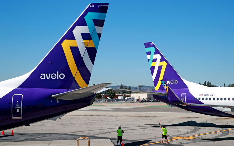 Airplanes sit on a tarmac.