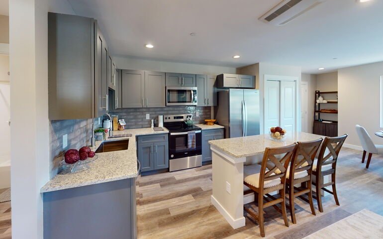 An apartment kitchen has an island counter.