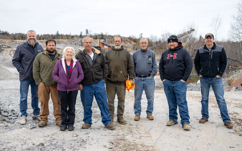 A group of people pose in a quarry.