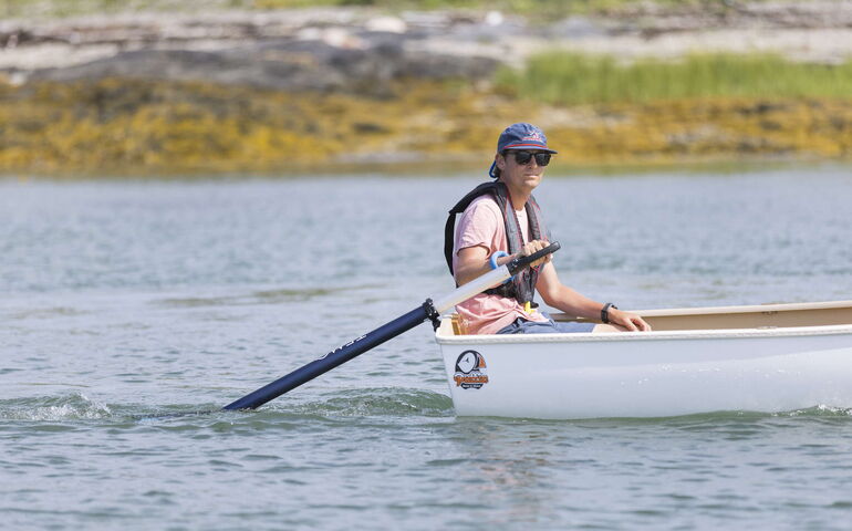 A person in a boat holds an electric motor.