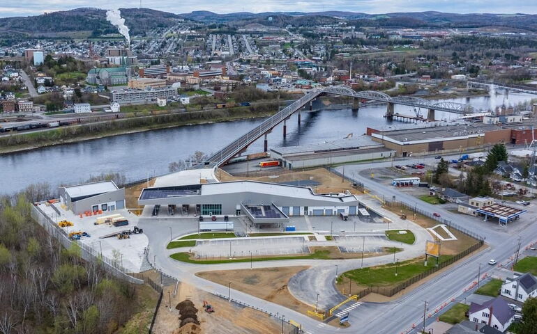 A bridge and port of entry are at a river.