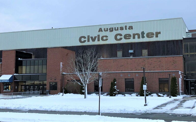  The exterior of a blocky building has snow on the ground.