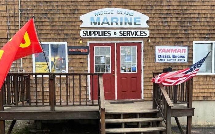 The front of a store has flags and cedar shingle siding.