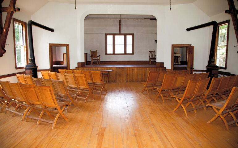 A theater has chairs and a wood floor.