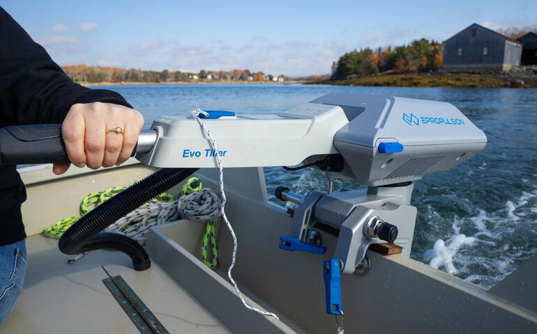 a hand  holds the tiller of a motor.