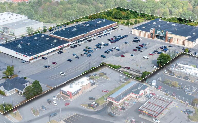 An aerial photo shows a shopping center with parking lots.