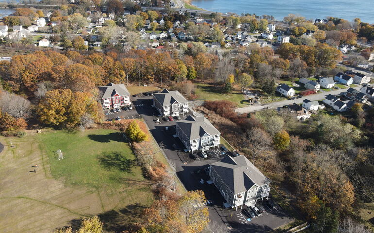 An aerial view of multiple buildings, trees and fields.