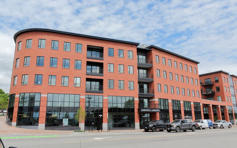 The exterior of a red brick building has a curved corner.