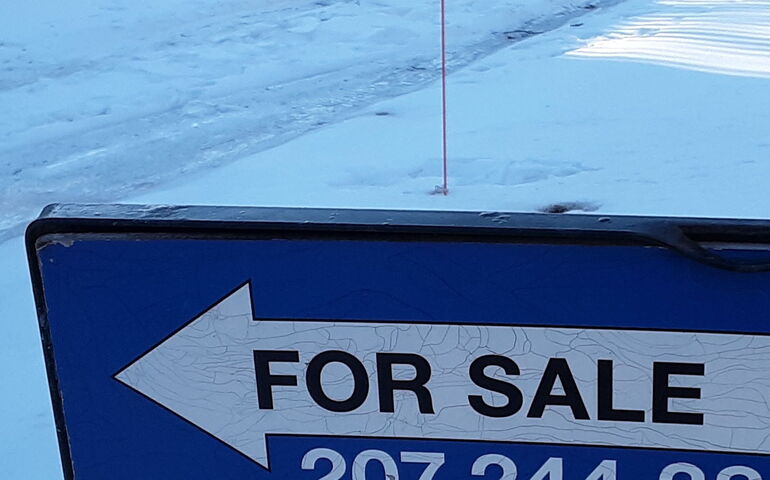 Part of a sign surrounded by snow.