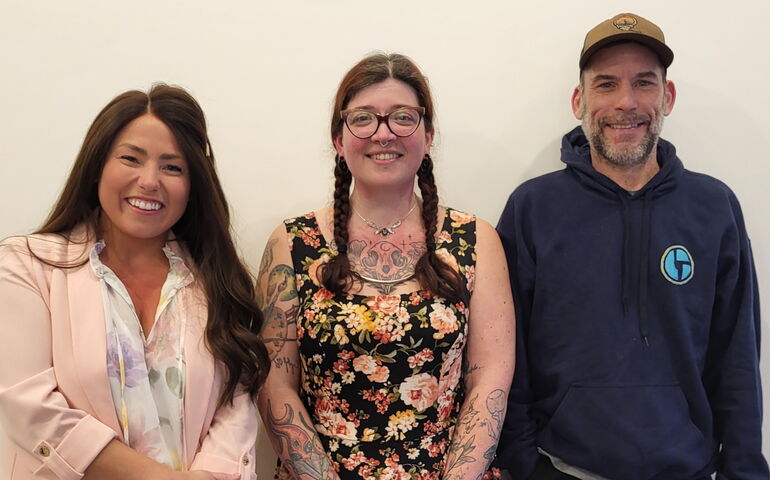 Three people pose for a photo.