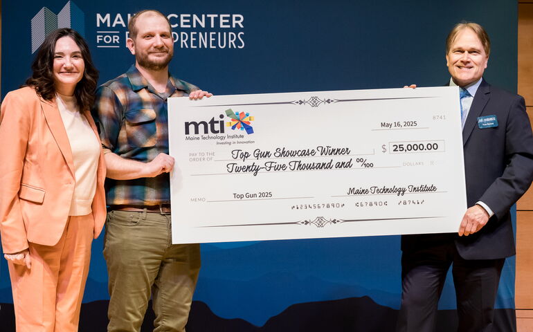three people holding big check at Top Gun event
