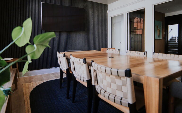 A room has a long table and chairs.
