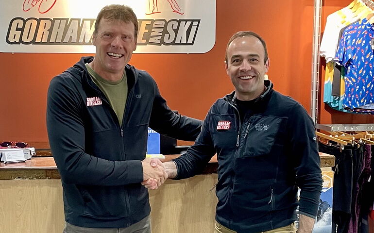 Two people pose for a photo shaking hands.