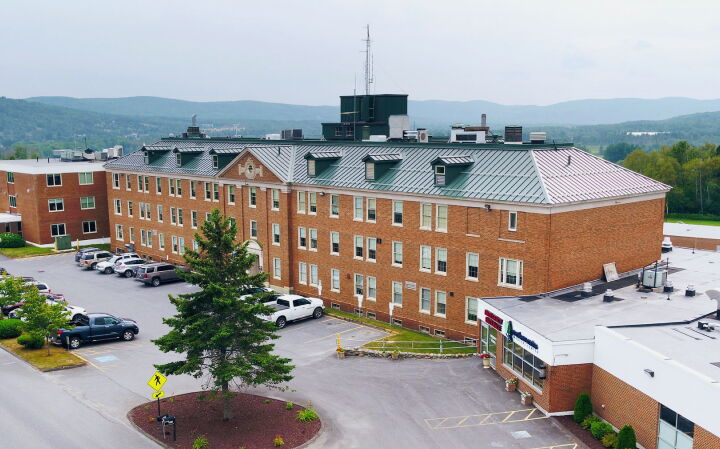 An aerial view of a brick building and parking lot.