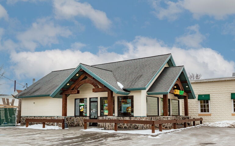 A tan-sided building has a portico.