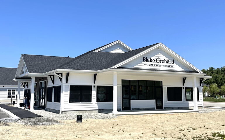 White building with black writing on a sign that says Blake Orchard 