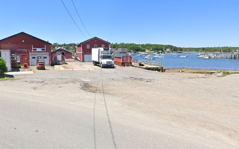 A view of a harbor with buildings and a parking lot.