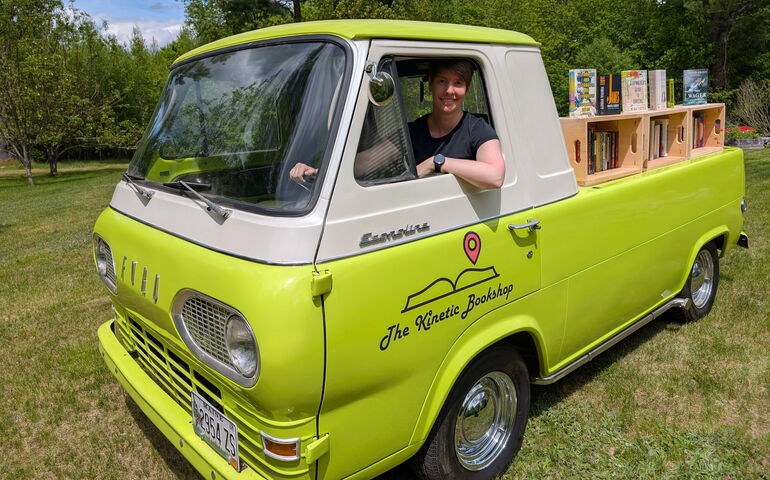 Jill Conner in lime-green pickup truck with books on the back 