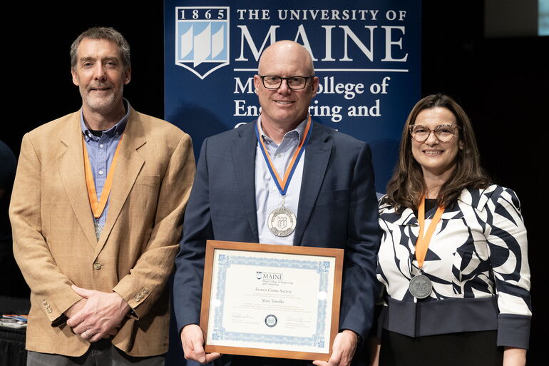 three people at an awards ceremony