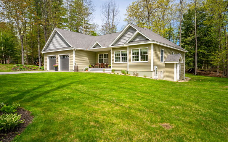 A house has a green rolling lawn.