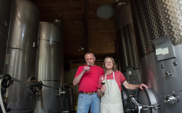 Two people stand surounded by machinery.