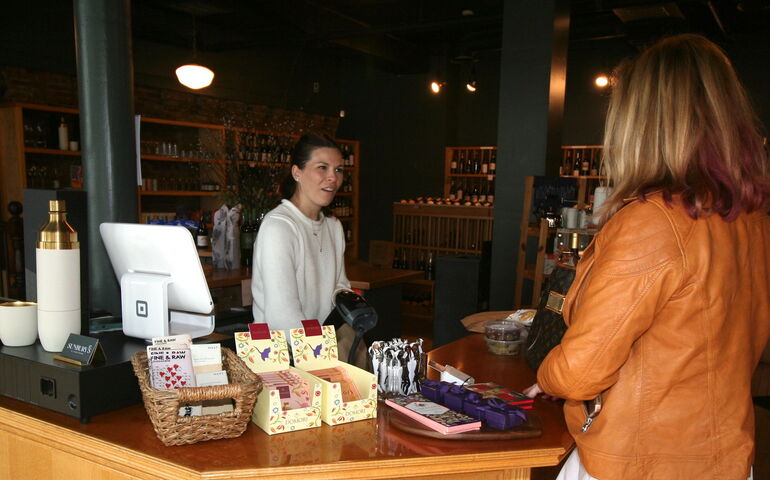 Two people talk at a counter.