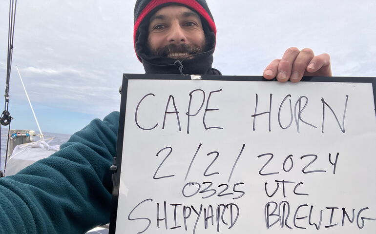 A person is bundled up and holds a whiteboard.