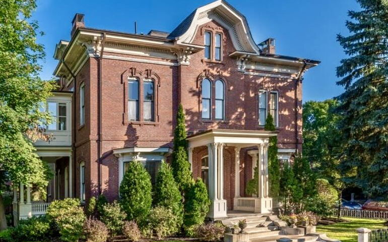A brick house has a metal fence.