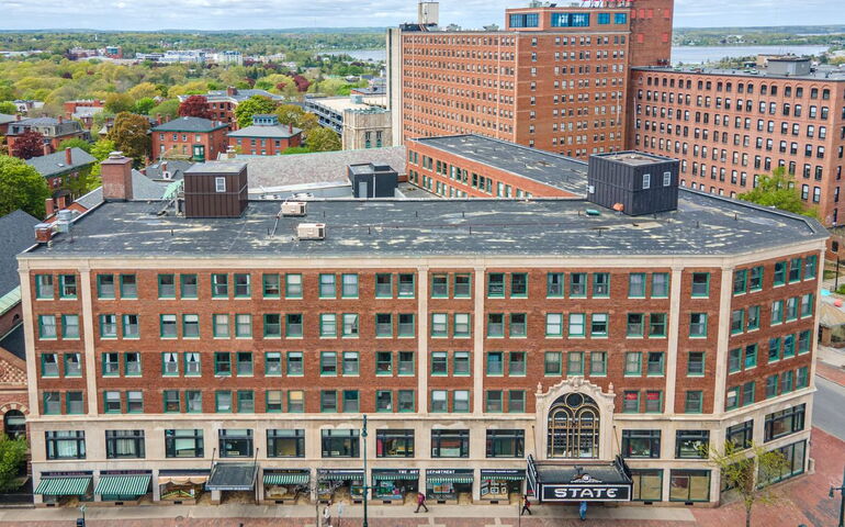 An aerial view of an L-shaped brick buildling.