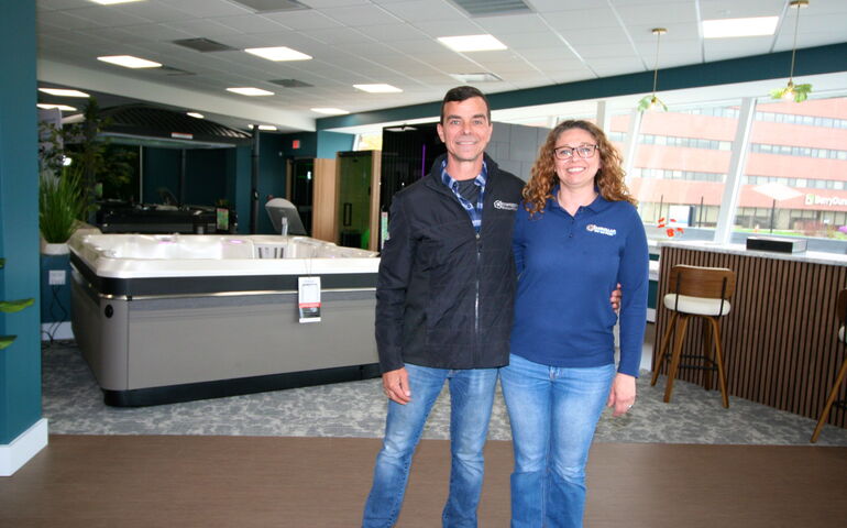Two people pose with hot tubs.
