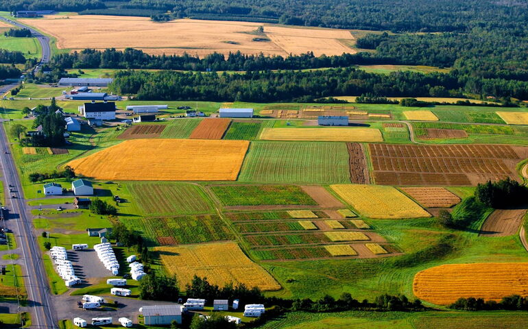 An aerial view shows fields and buildings.
