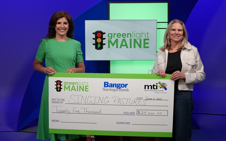 Winner of Greenlight Maine and series host holding oversized check 