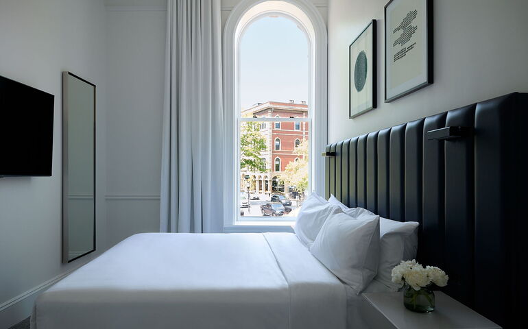 A bedroom has an arched window.