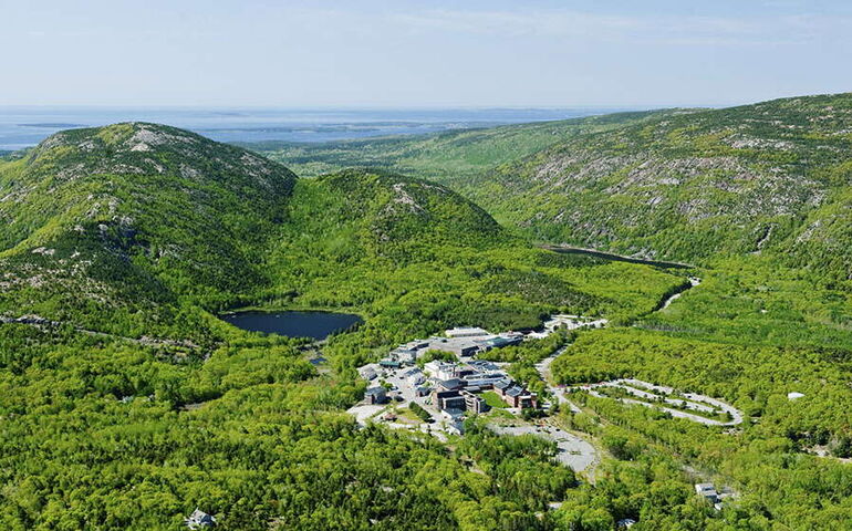 An aerial view shows buildings amidst woods.