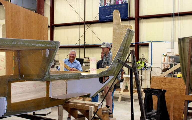 People work on structures in a shop.