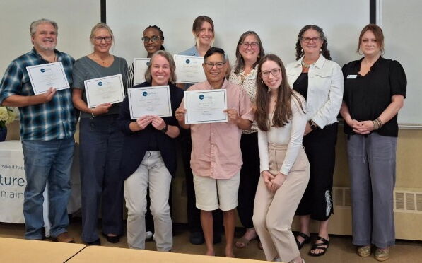 People line up and hold certificates.