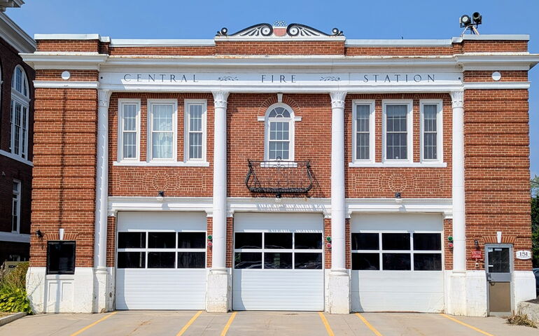 A brick building has three garage doors.