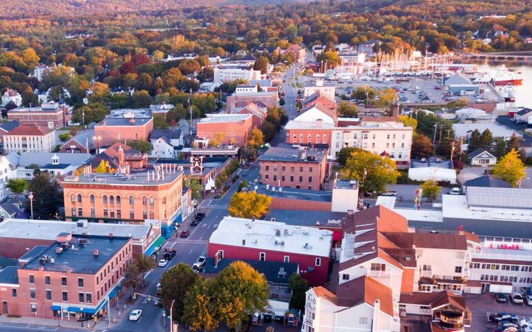 An aerial view shows buildings and streets.